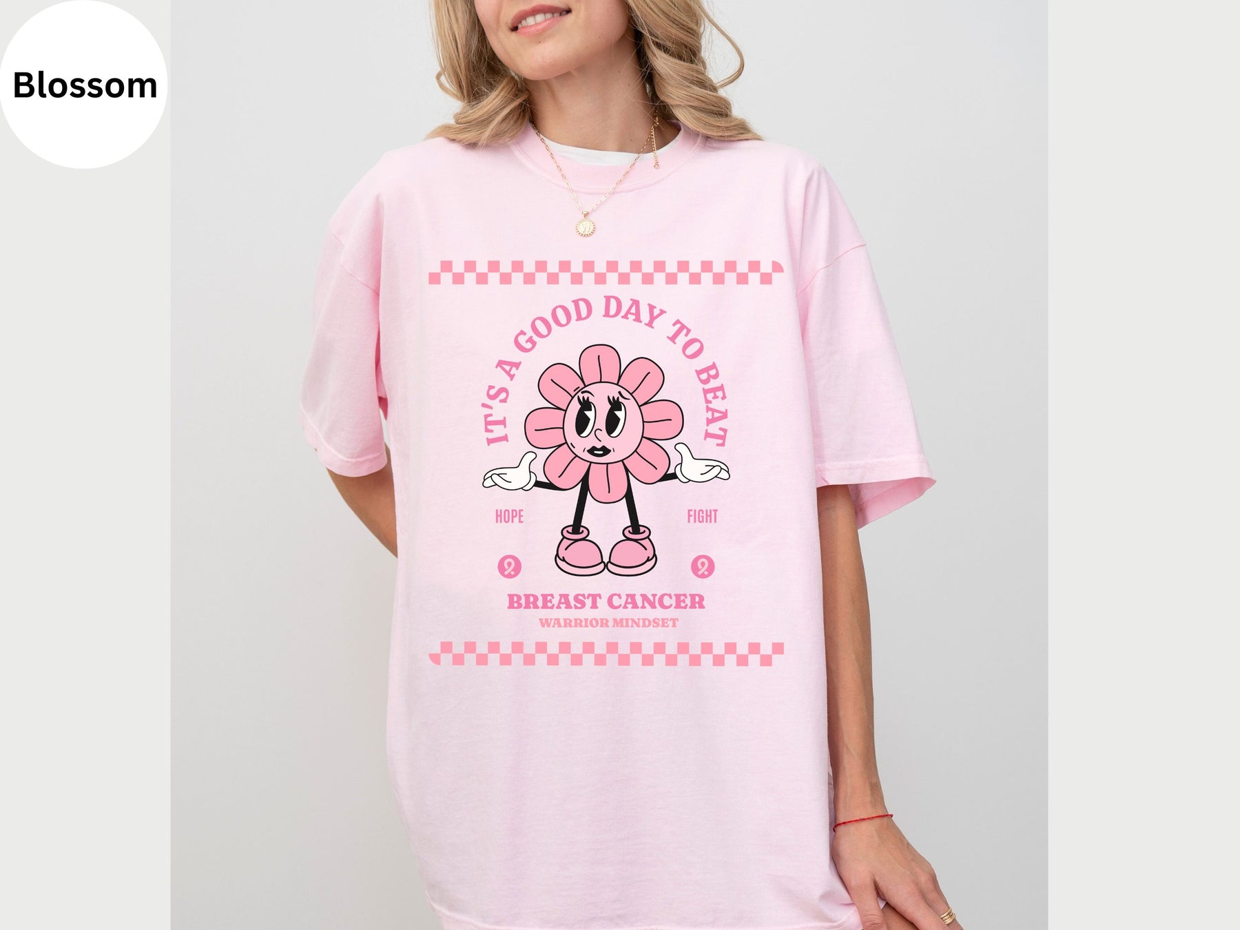 a woman wearing a pink shirt with a flower on it