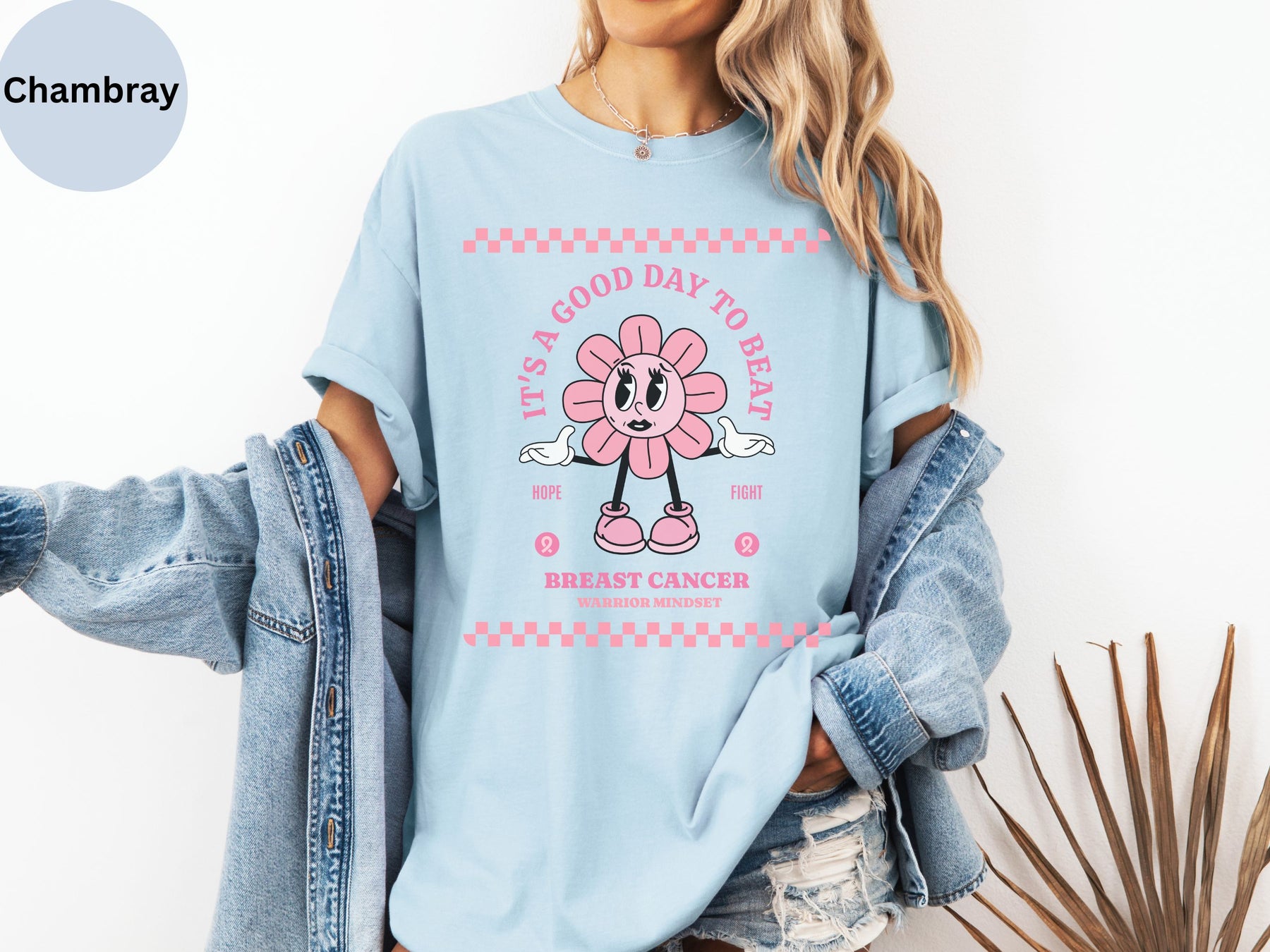 a woman wearing a blue shirt with a pink flower on it