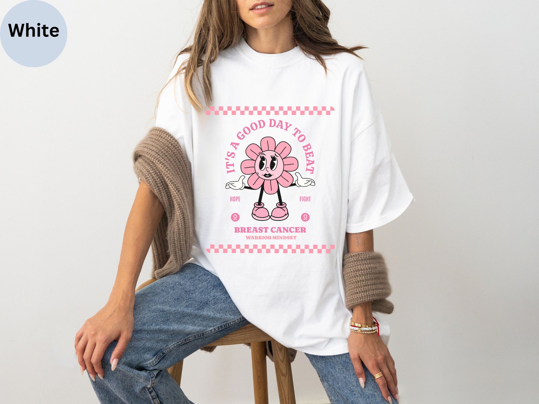 a woman sitting on a stool wearing a t - shirt