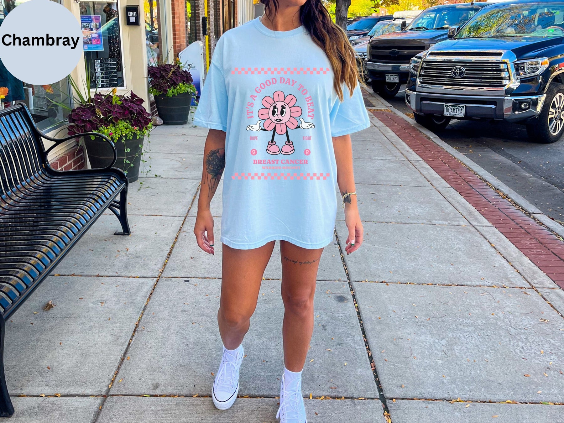 a woman in a blue shirt and shorts standing on a sidewalk