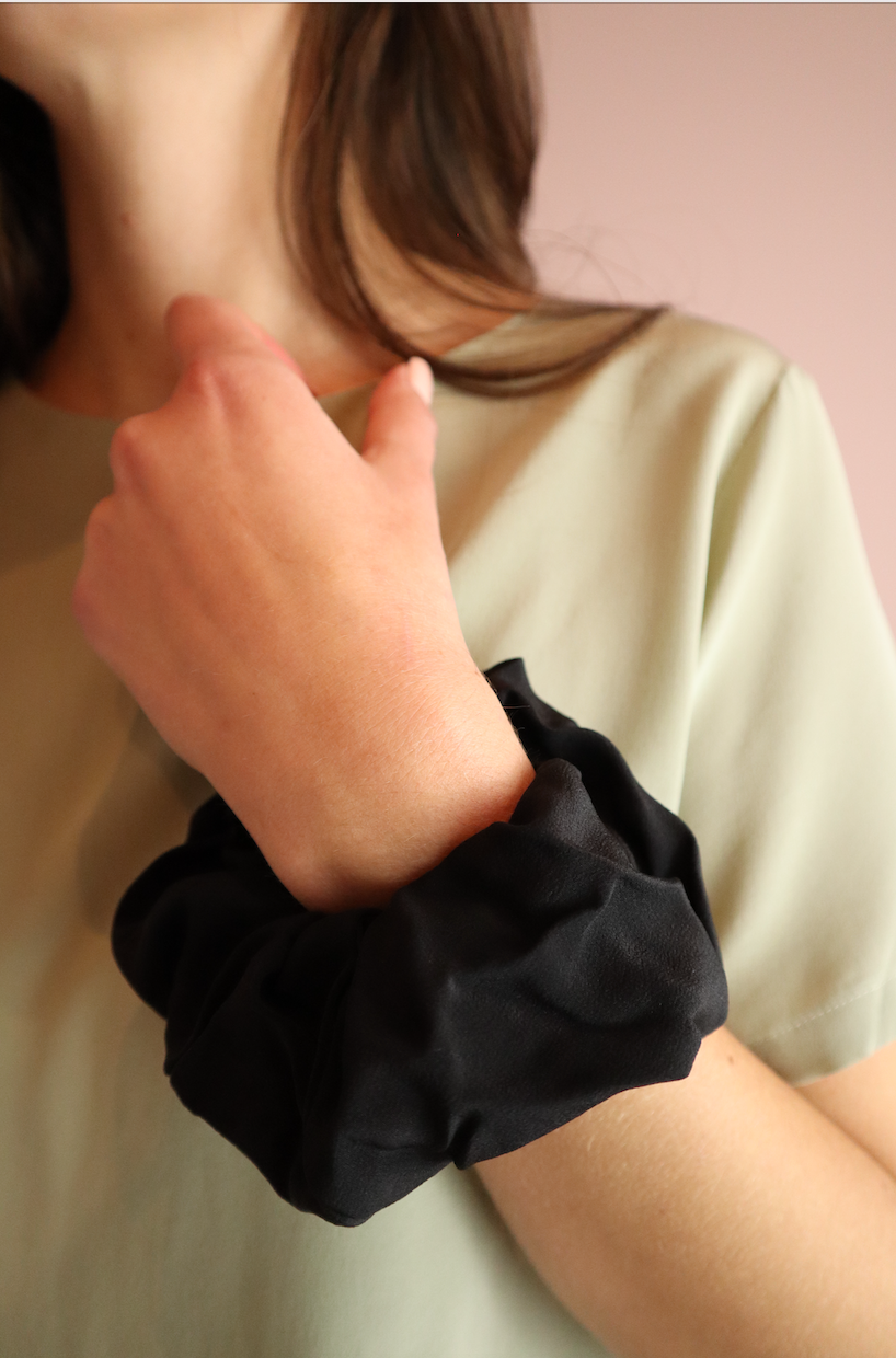 woman wearing sustainable black silk scrunchies wrist