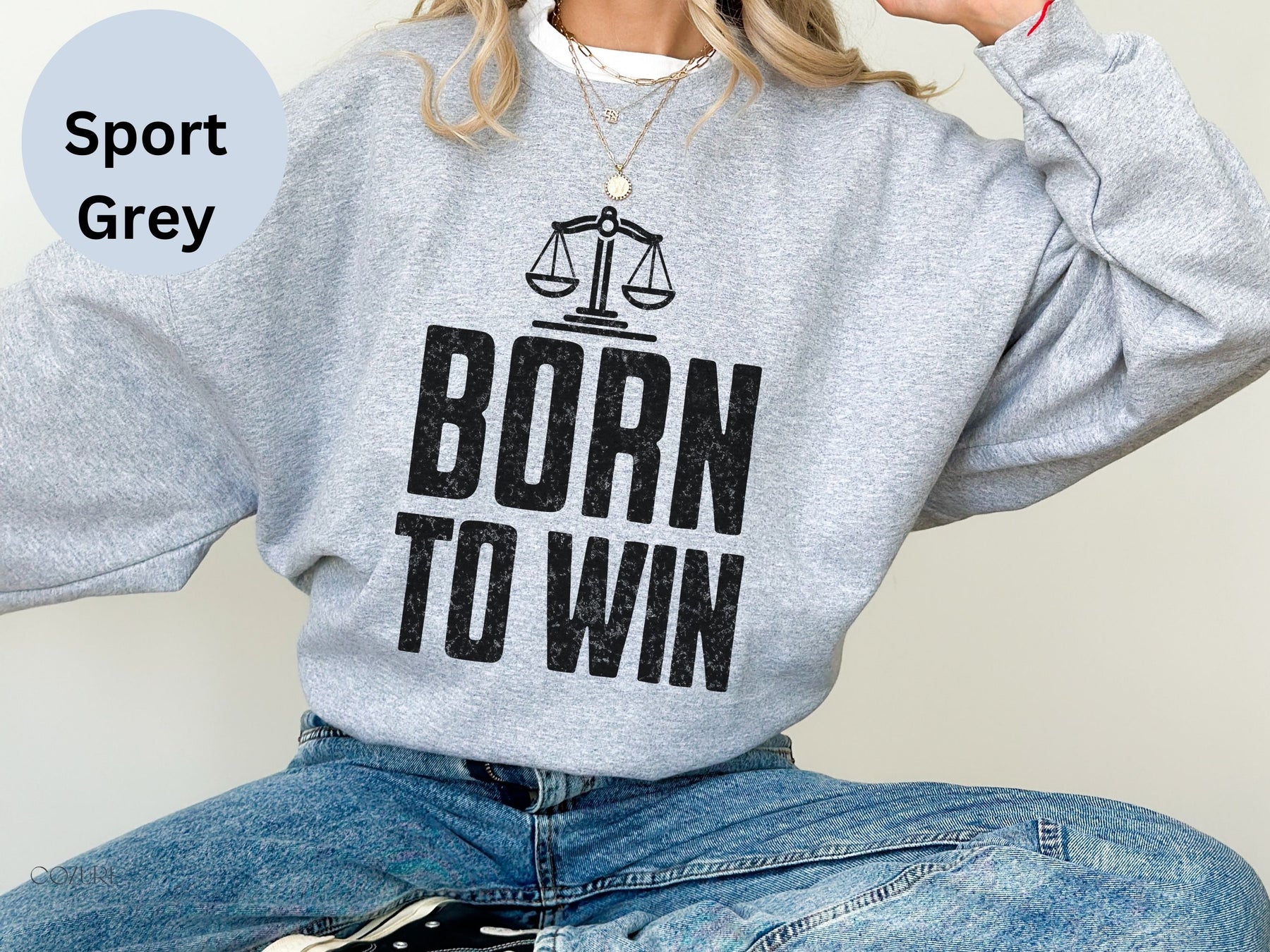 a woman wearing a sweatshirt that says born to win