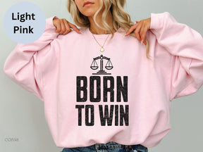 a woman wearing a pink sweatshirt with the words born to win printed on it