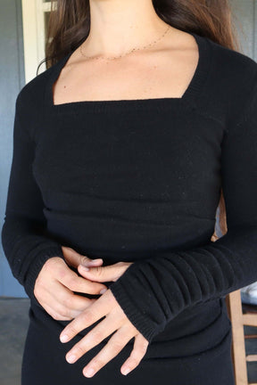 Close up of square neckline and sleeves of black cashmere sweater dress