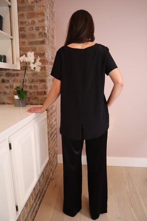 Woman wearing black silk pants paired with a black  silk top