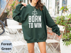 a woman in a green sweatshirt that says born to win