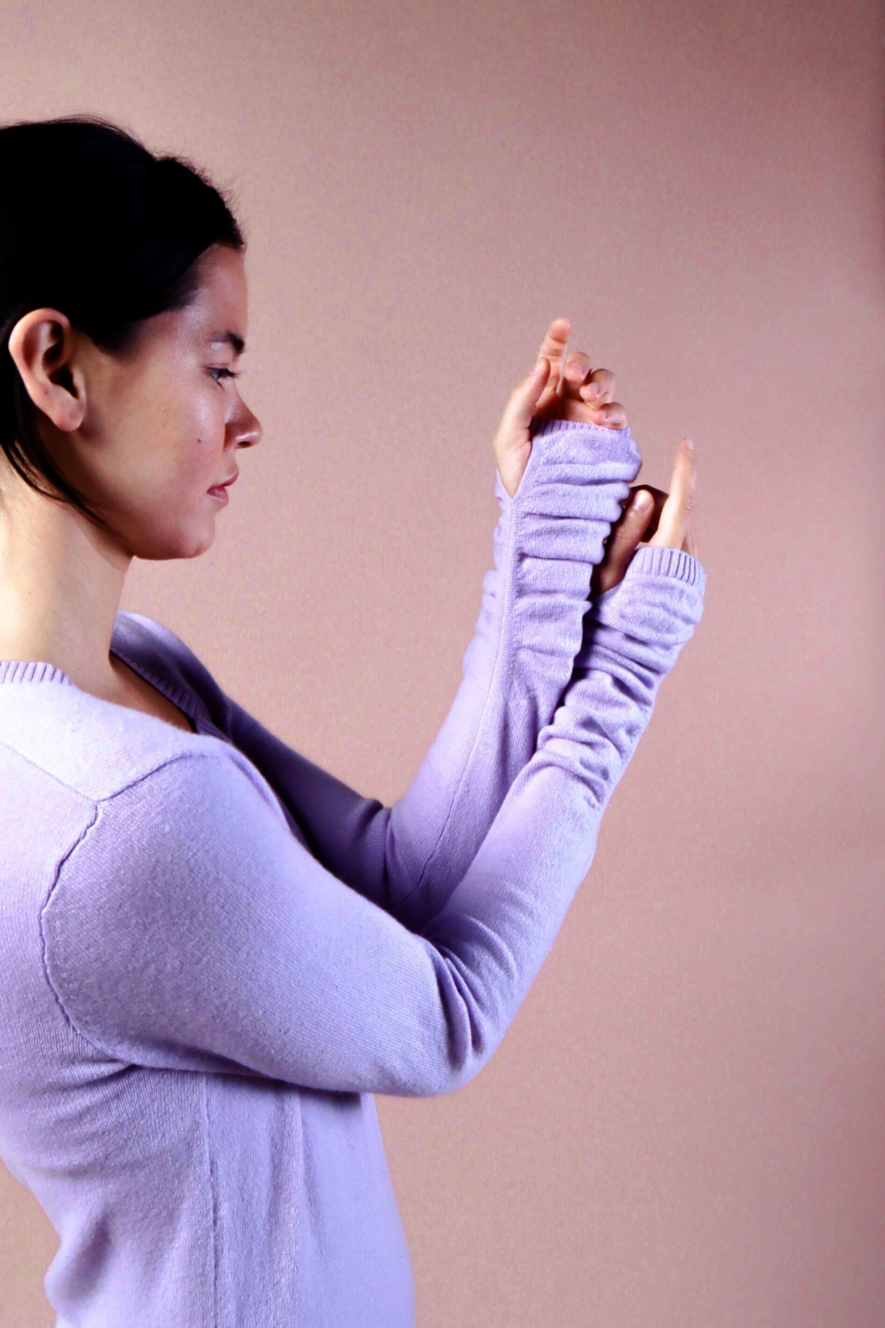  Woman wearing long sleeve lavender sexy cashmere sweater dress close up of sleeves and thumbholes at wrist