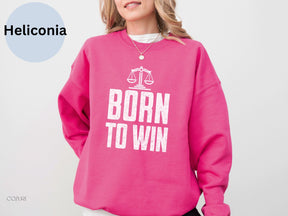 a woman wearing a pink sweatshirt that says born to win