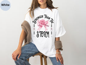 a woman sitting on a stool wearing a t - shirt with a pink rose on