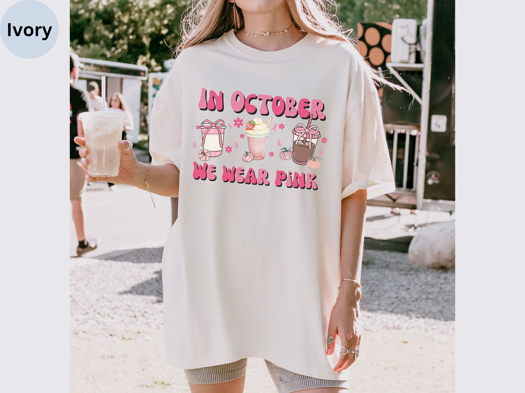 a woman holding a drink and wearing a t - shirt