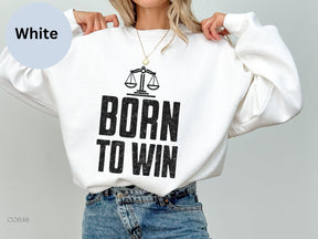 a woman wearing a white sweatshirt with the words born to win printed on it