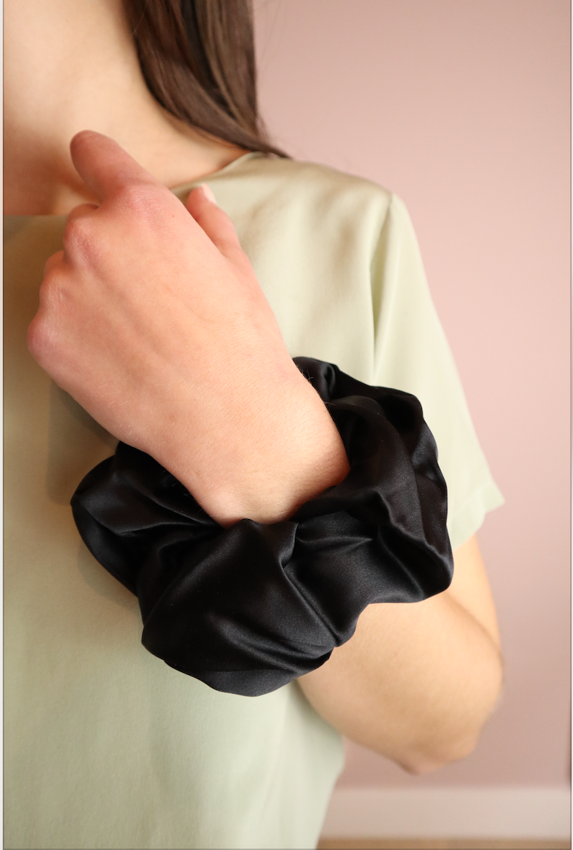 woman wearing sustainable black silk scrunchies wrist