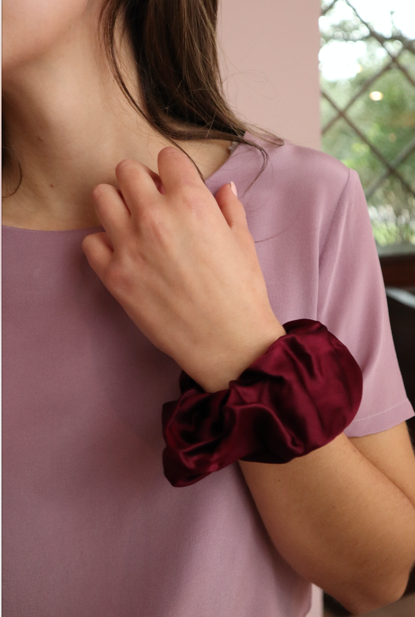 woman wearing sustainable red silk scrunchies wrist