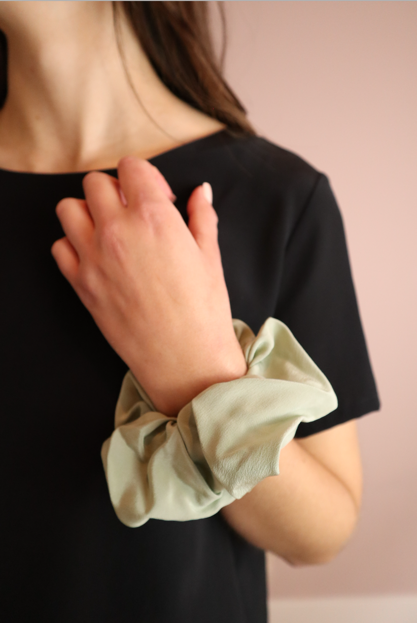 woman wearing sustainable green silk scrunchies wrist